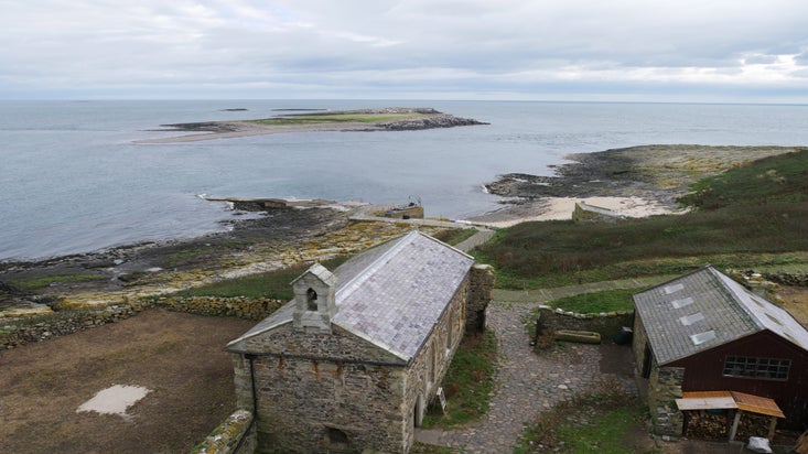 View of St Cuthbert's chapel from above, with the sea beyond.